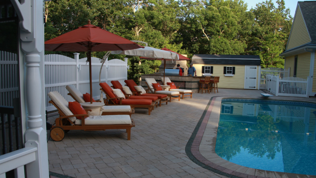 Lounge by the in-ground pool on patio seating.