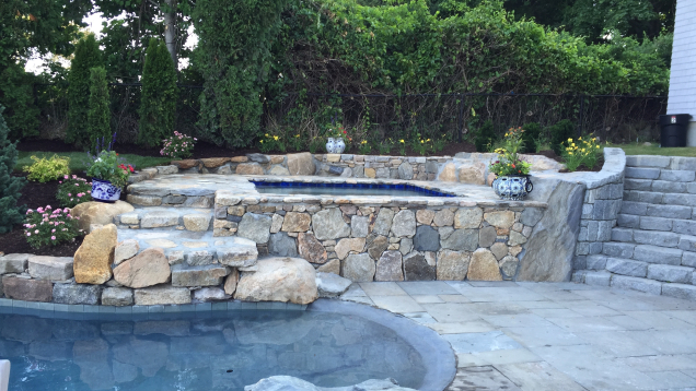 In-ground gunite pool with natural stone steps, accents and wall.